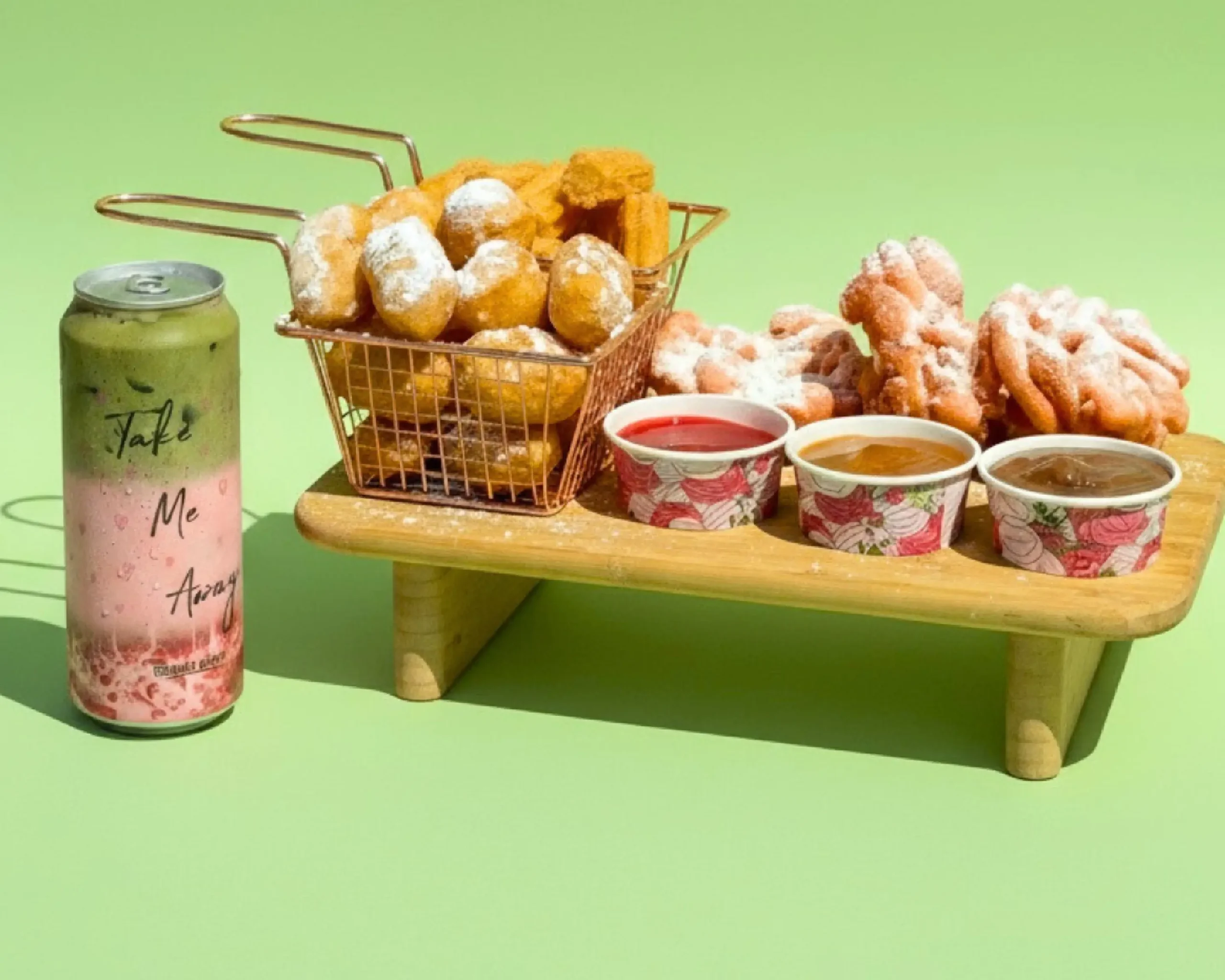 A stylized overhead dessert charcuterie board with candies, waffles, ice cream bites, and a gourmet coffee.